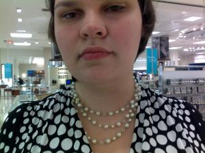 A picture of me wearing a simple tripple strand of white pearls. They're all around the same length, i.e. a little below my collarbone 